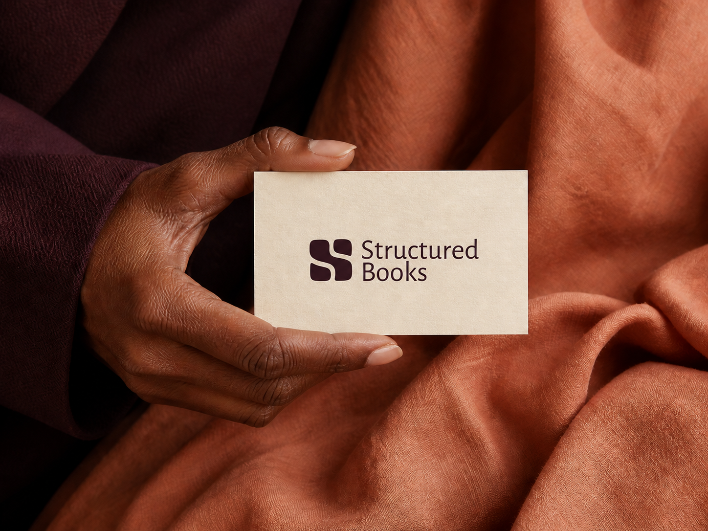 Structured Books stationery held against warm clay-toned fabric